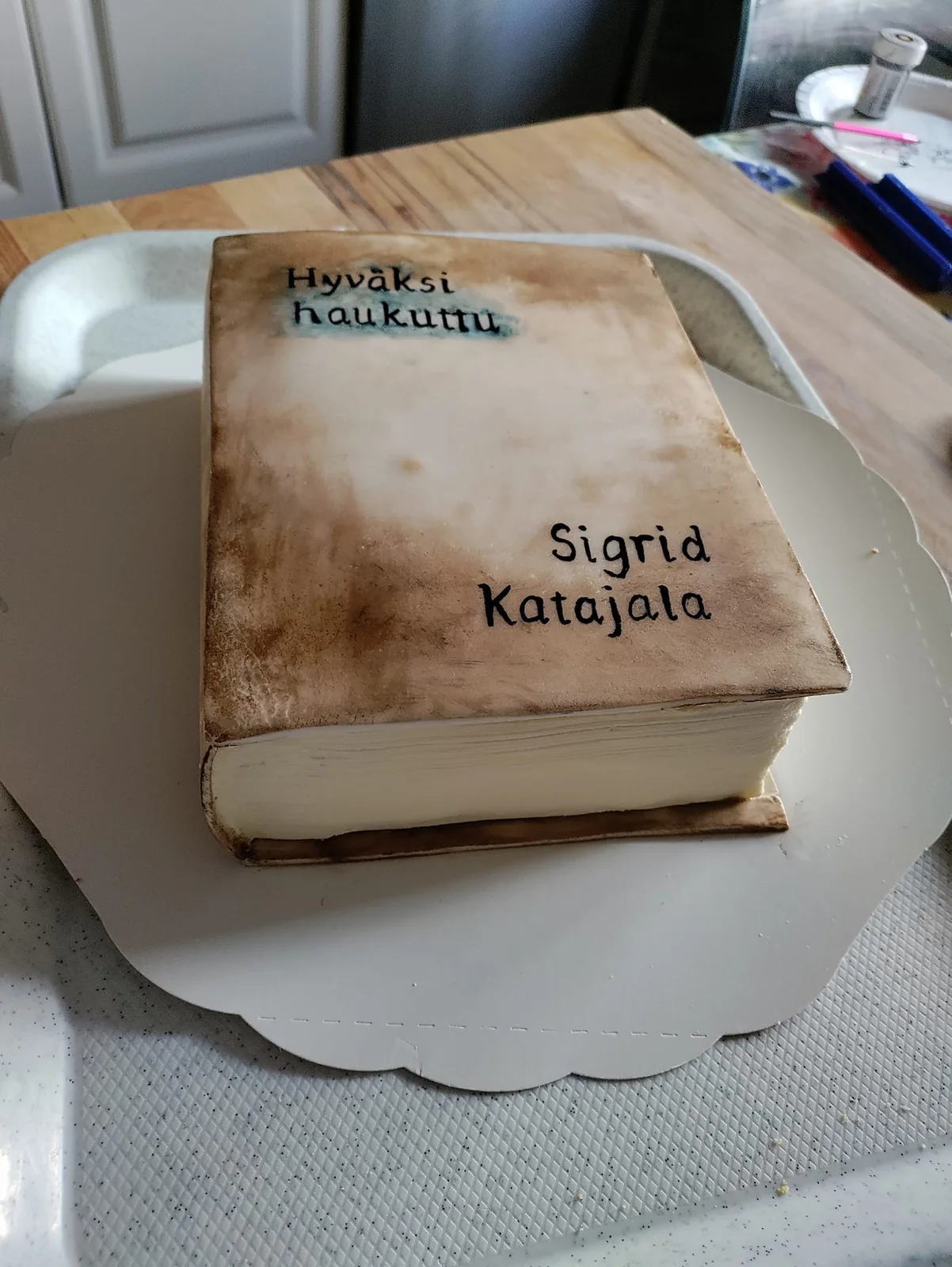 Kirjan muotoinen tilauskakku, jonka kannessa lukee Hyväksi haukuttu